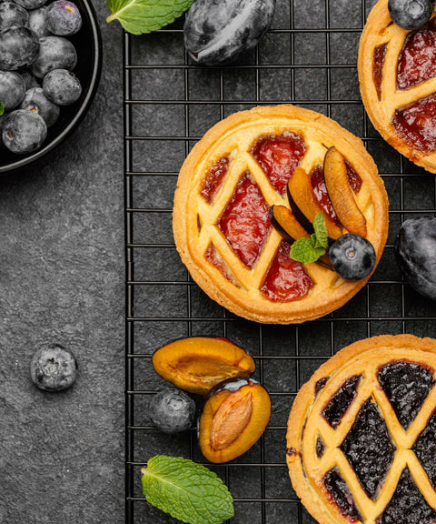 Golden-brown pies with flaky crusts, both savoury and sweet varieties, cut open to show their rich fillings.