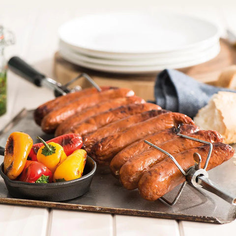 Grilled Brazilian BBQ Brat on a metal skewer with peppers on a wooden board.