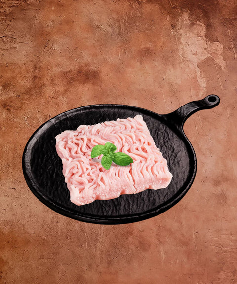 Raw ground meat on a black cast iron skillet with a brown background