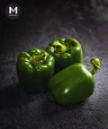 Three pieces of green capsicum on a dark background