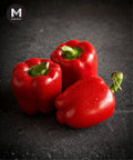 Three red capsicum on a dark backrground