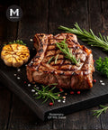 Grilled rib steak with rosemary and garlic on a dark wooden board