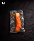 Vacuum-packed NZ King Salmon fillet marinated in Umami Dashi, flesh side up on black background