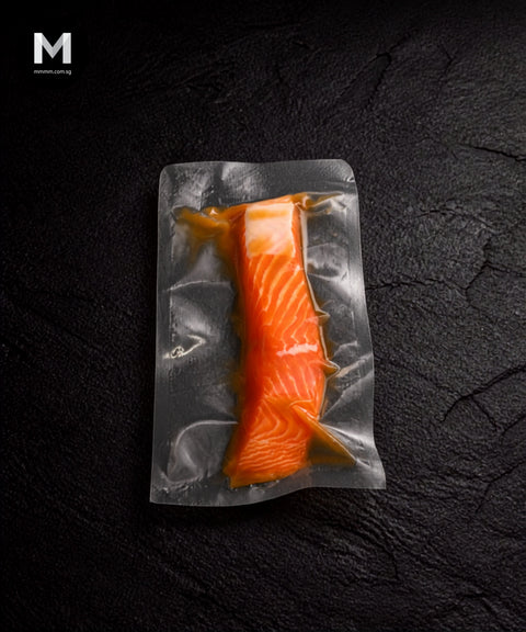 Vacuum-packed NZ King Salmon fillet marinated in Umami Dashi, flesh side up on black background