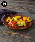 Cheese stuffed baby capsicum on a wooden platter