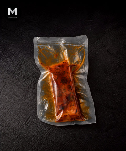 Vacuum-packed Australian Trout fillet marinated in Cajun spice blend, on black background