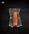Vacuum-packed Australian Trout fillet marinated with lemon and cracked pepper, on black background