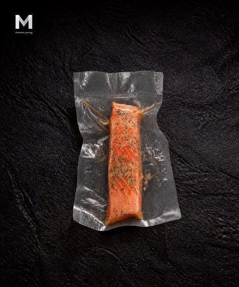 Vacuum-packed Australian Trout fillet marinated with lemon and cracked pepper, on black background