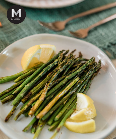 Roasted asparagus with lemon wedges on a plate