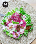 Candy cane beet salad with feta, pecans, and sun-dried tomatoes on lettuce