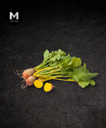 Baby golden beetroot, whole and halved showing golden flesh, on a black background