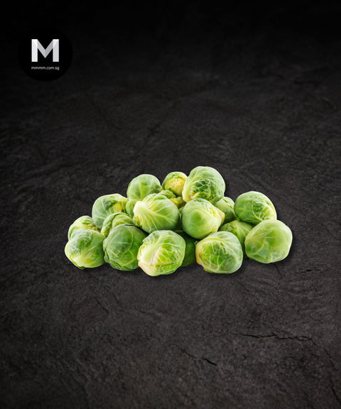 Raw brussels sprouts piled on a black background