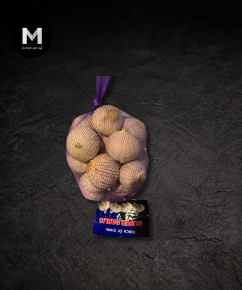 Fragrant garlic bulbs packed in a bag on a black background