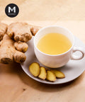Old Ginger root with sliced pieces and a cup of ginger tea