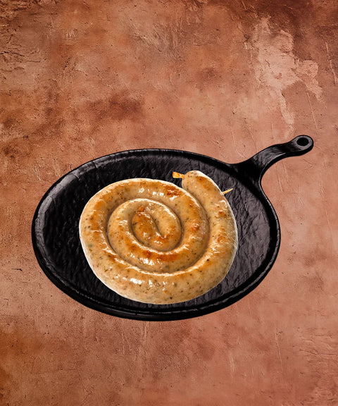 Spiral-shaped bread roll in a black cast iron skillet on a brown background