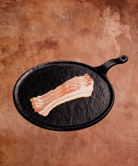 Raw bacon on a black skillet