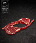 Australian Angus grainfed Tomahawk steak shown from an alternate angle on a black background