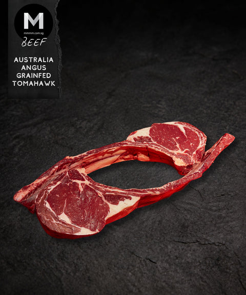 Australian Angus grainfed Tomahawk steak shown from an alternate angle on a black background