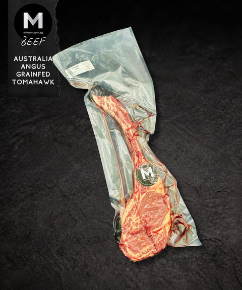 Vacuum-sealed Tomahawk steak in Mmmm! packaging, 1.3kg, on a black background