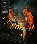 Grilled Tomahawk steak with charred crust cooking over open flame on the BBQ