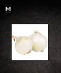 Peeled white onions on a plate against a black background